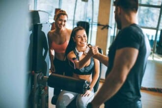 young woman having exercises leg extension leg curl machine gym