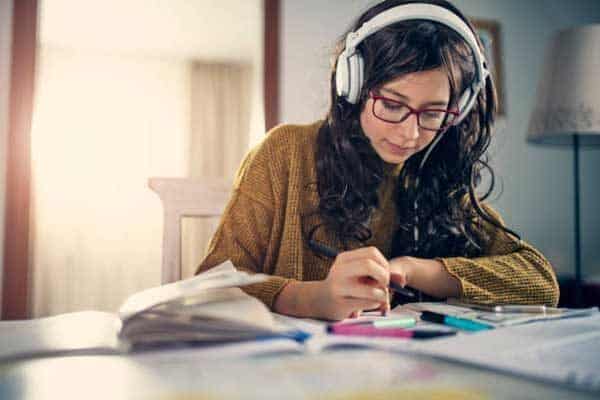 a girl making her to do list while listening music 1