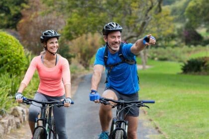 athletic couple pointing while riding bicycle