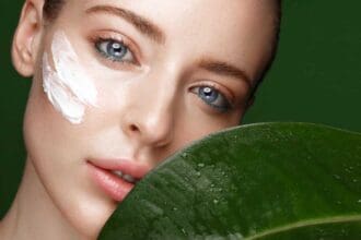 beautiful fresh girl with cosmetic cream face natural makeup green leaves beauty face