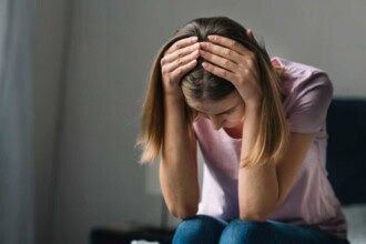 close up sad young woman holding her head