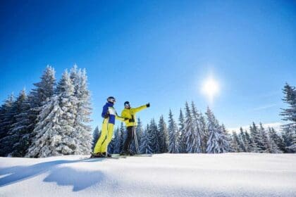couple skiers skis hill ski resort recreational activities mountains concept low angle full length shot