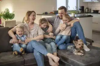 family portrait family photo which mom dad daughters son dog are smiling hugging couch cozy homely atmosphere