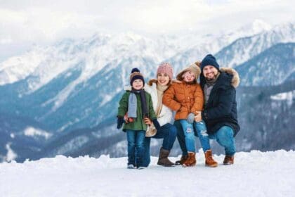 front view happy family skiers standing together top mountain while getting ready their adventure