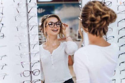 girl is standing with set glasses background optical shop stand with spectacles eyesight correction woman is wearing glasses