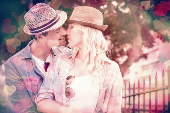 hip young couple kissing by railings sunny day city