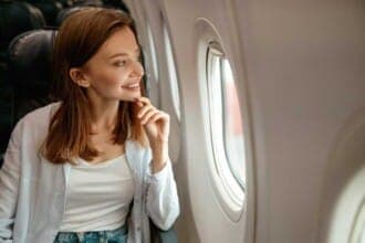 joyful woman looking out window airplane