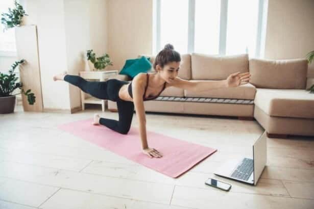 lovely young woman sportswear is doing fitness home floor looking tutorial laptop