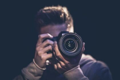 man photographer with camera takes photo dark