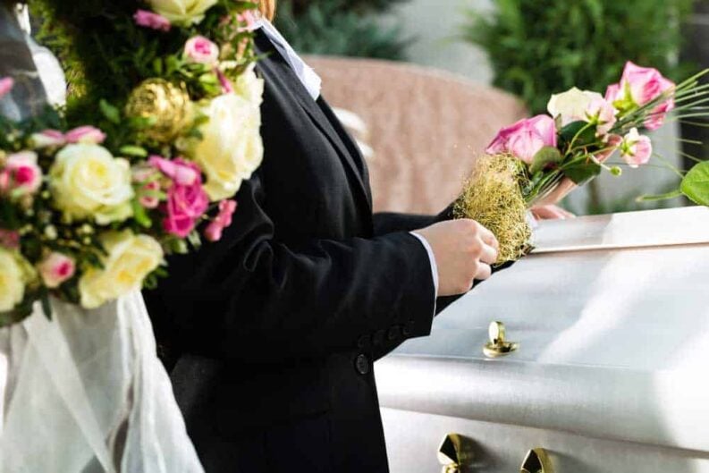 mourning man woman funeral with pink rose standing casket coffin