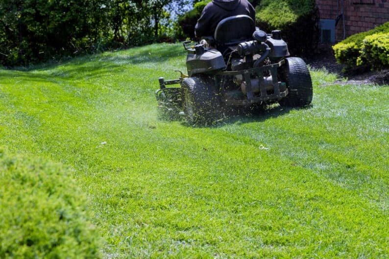 municipal worker mows lawn mower gardener cuts grass