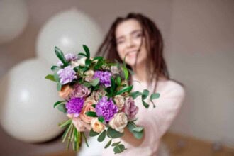 portrait beautiful young woman summer dress straw hat holds carnation roses bouquet looking her shoulder