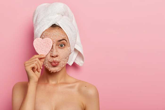 reducing pores cleansing concept attractive female applies sea salt mask face has luxurious feelings from beauty treatments covers eye with heart shaped sponge pampers