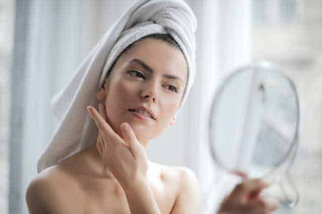 selective focus portrait photo of woman with a towel on head 3764013