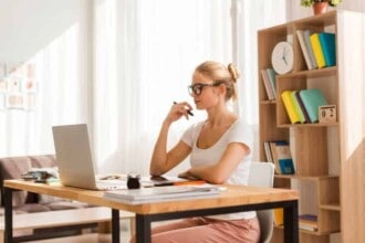 side view woman working laptop from home desk