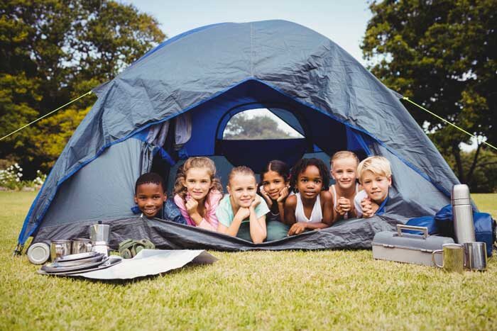 smiling children lying tent together
