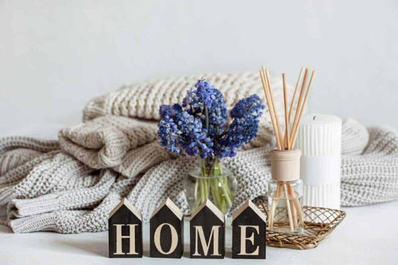 spring home composition with flowers aroma sticks knitted element decorative word home