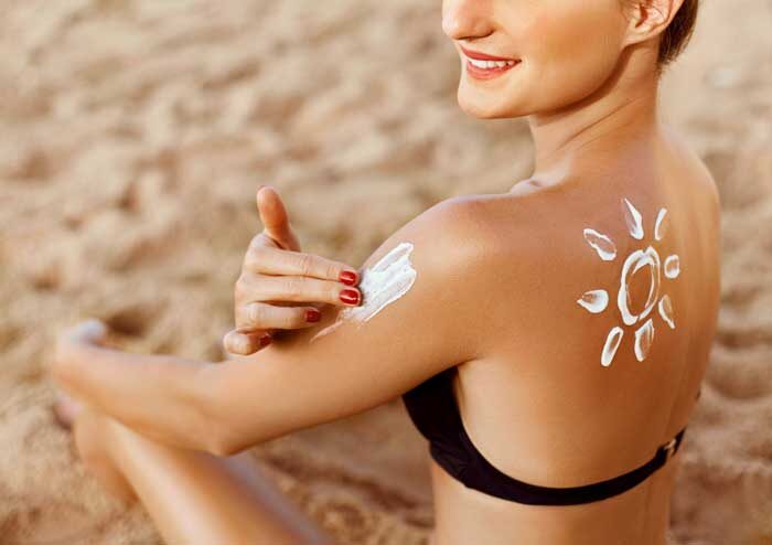 suntan lotion young woman applying sunscreen solar cream beach sun shape shoulder