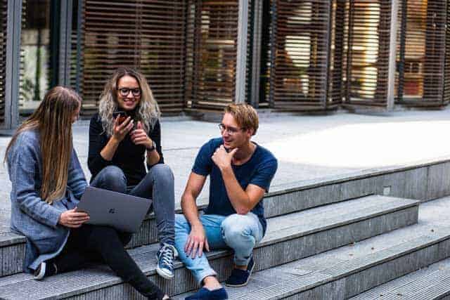 three persons sitting on the stairs talking with each other 1438072 1