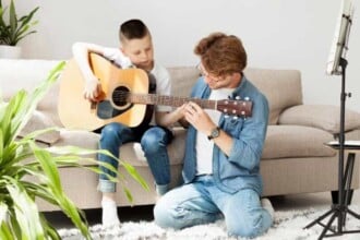 tutor boy learning how play guitar long shot