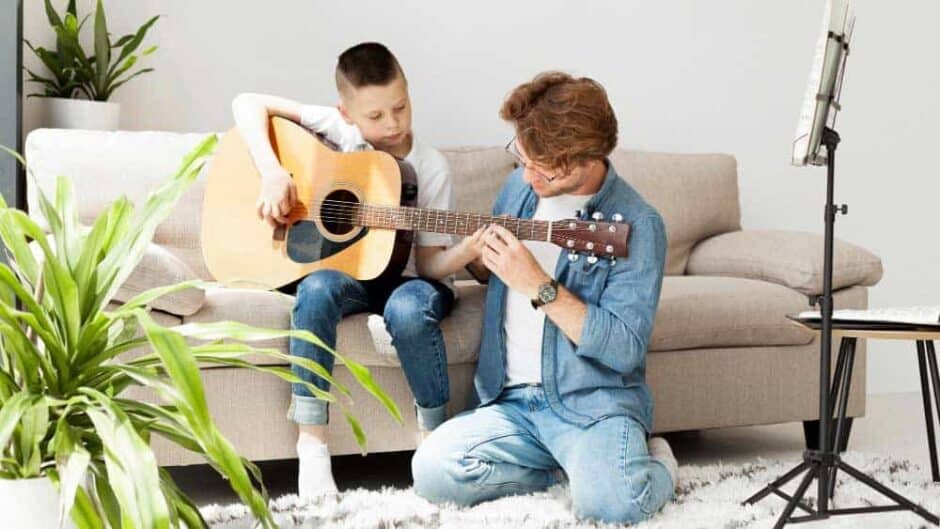 tutor boy learning how play guitar long shot