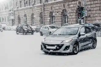 vehicles covered with snow during winter blizzard extreme snowfall european city cars move snowy road during heavy snowstrorm town