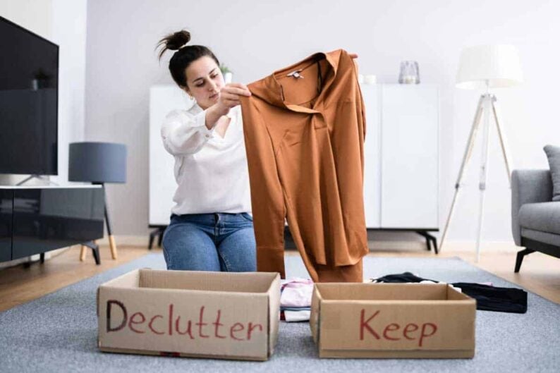 woman decluttering clothes sorting