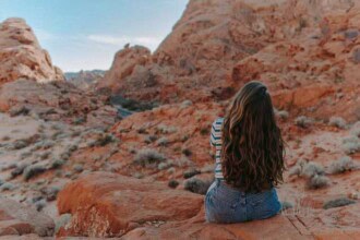 woman in blue denim shorts sitting on brown rock mountain 3935704