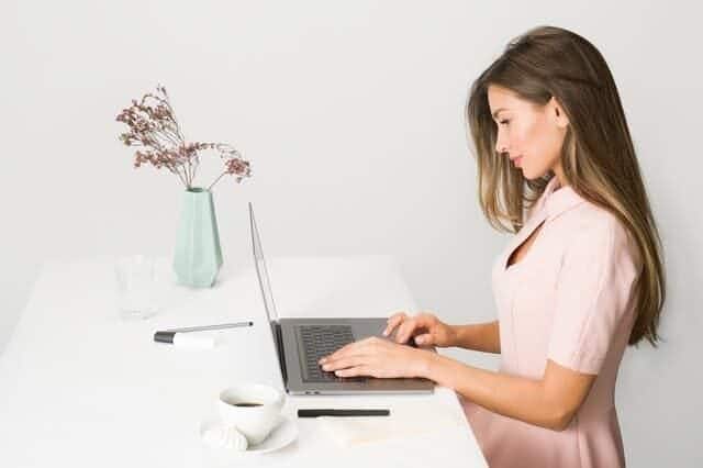 woman in pink dress using laptop computer 1586973