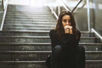 woman sitting look worried stairway