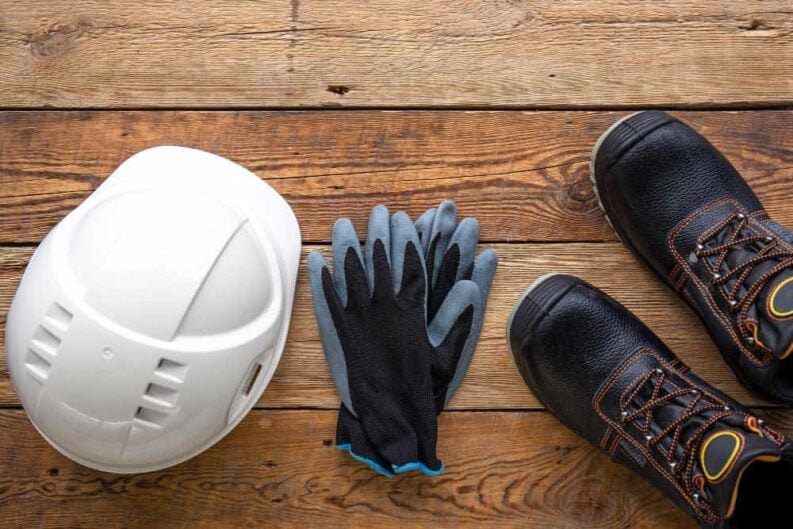 work helmet boots gloves wooden background top view