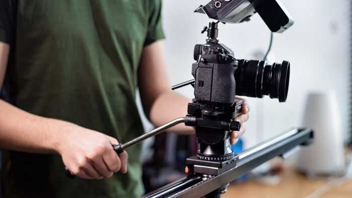 young content creator man filming with camera slider professional rig