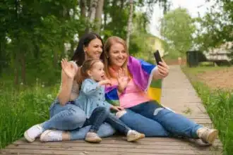 young happy cheerful lgbt married couple with funny laughing daughter