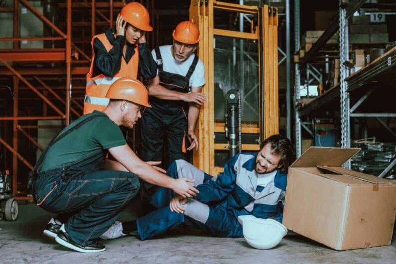 young warehouse worker injured leg workplace