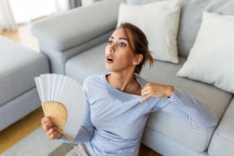 woman using waving fan suffer from overheating summer