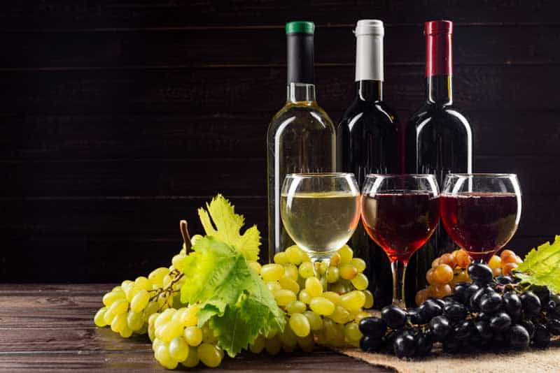 Wine bottle and grape on wooden table