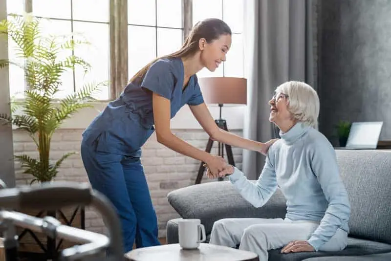 professional caregiver taking care of elderly woman at home