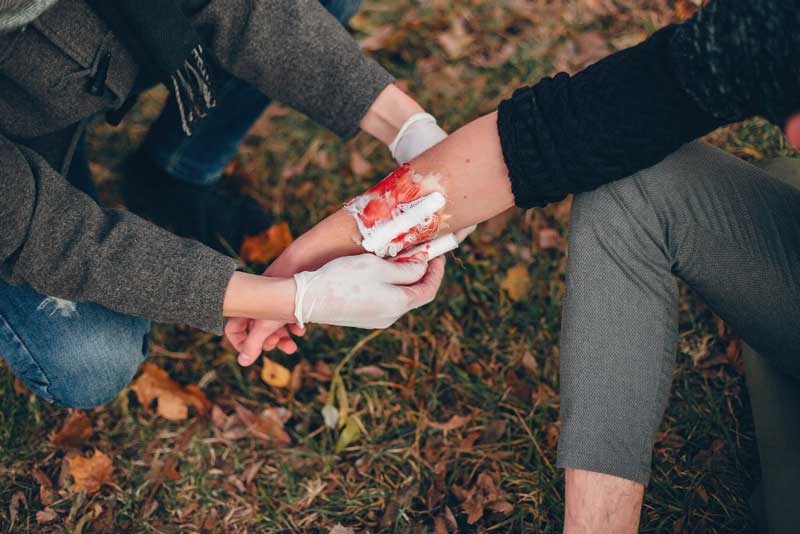 providing first aid park man bandaged injured arm guy helps friend