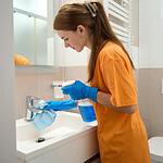 Female from cleaning company cleaning washroom fixtures